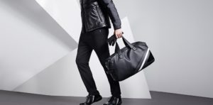 homme habillé en noir avec un sac à la main