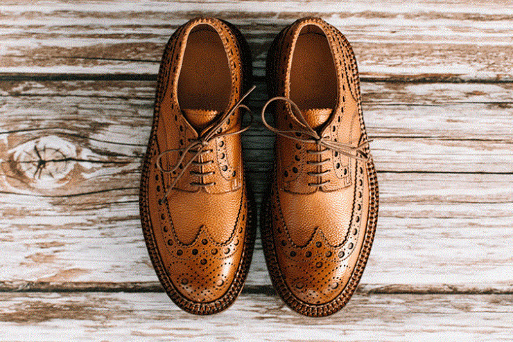 une paire de chaussure brogues marron sur du bois
