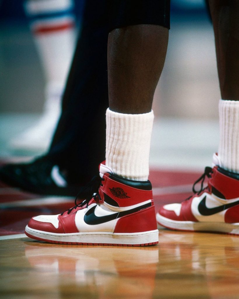 Une paire de Air Jordan 1 Chicago aux pieds de Michael Jordan sur un court