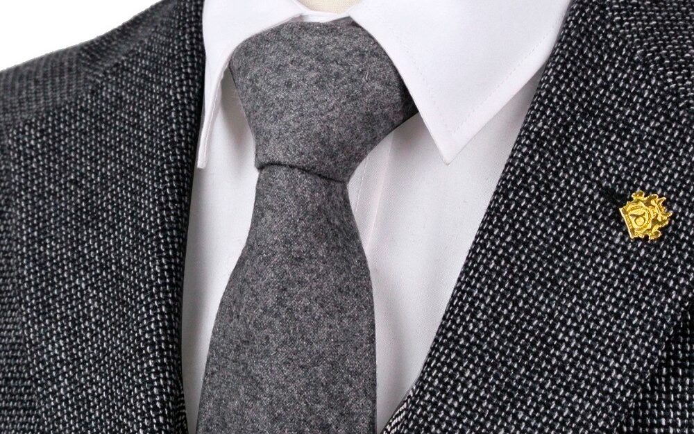 Cravate en soie grise associée avec un costume texturé et une chemise blanche