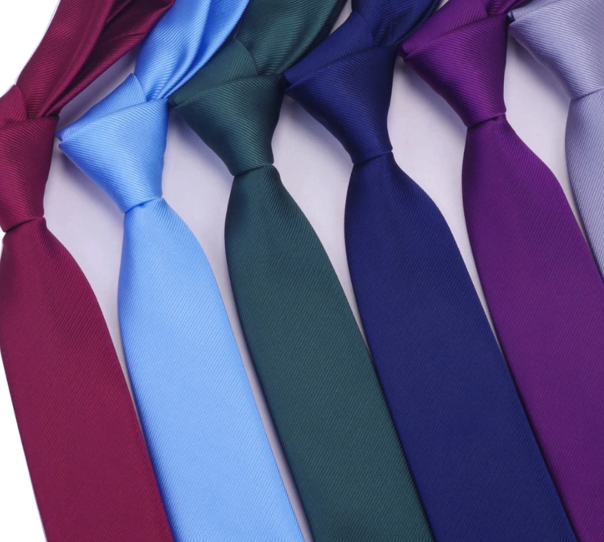 batch of several plain and knotted silk ties on a white background