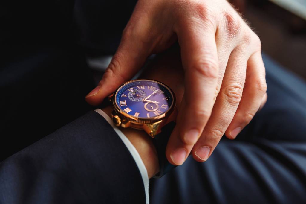 Homme portant une montre dorée au cadran bleu