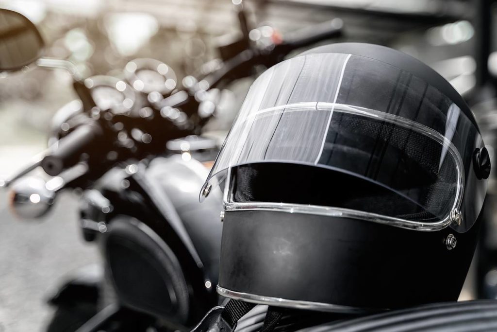 gros plan sur un casque de moto posé sur une moto noire