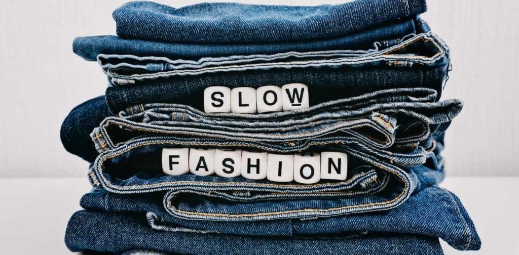 pile de jeans sur laquelle est marqué slow fashion