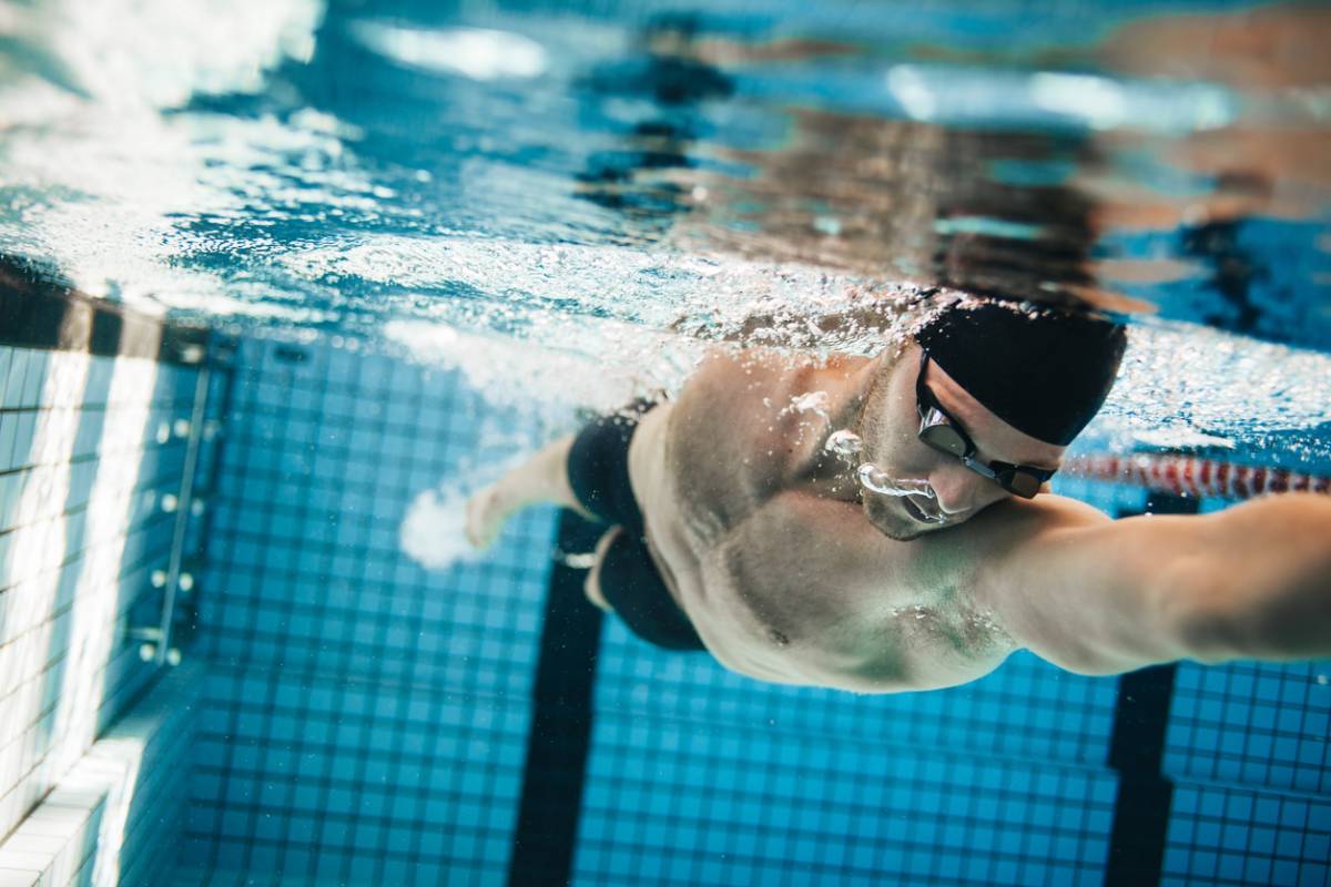homme nageant dans une piscine sous l'eau